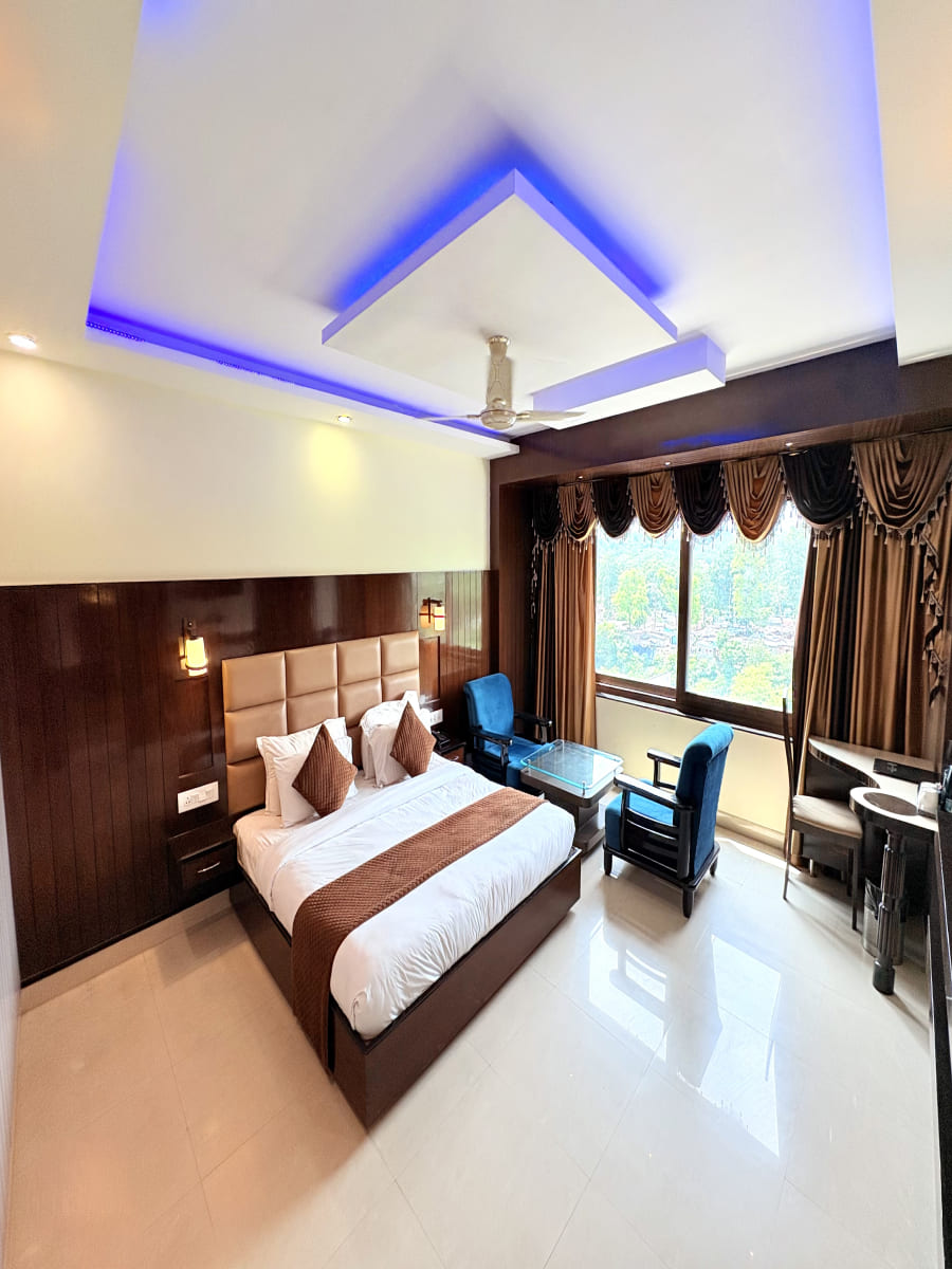 Cozy room at Hotel Crystal Ganga Heights in haridwar near har ki pauri ganga ghat with a comfy bed and seating area